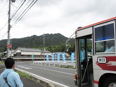 滋賀県田上の新免バス停に停車する帝産バスと背後に見える堂山"
