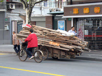 上海街なかをゆく、破壊された伝統木造建築の廃材（柱梁材？）を運ぶリアカー