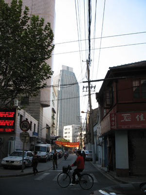 よくある町並みの奥に高層ビル聳える上海の朝