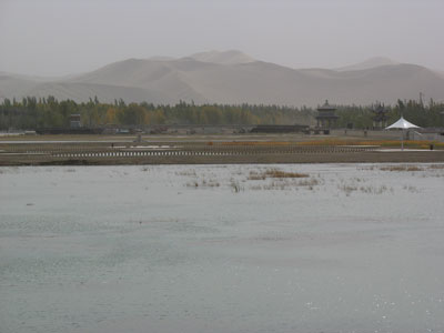 中国甘粛省西部の街「敦煌」から見た党河の水面と飛砂に煙る鳴沙山