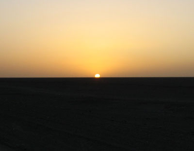 南湖から敦煌への帰りのバス内から見た、沙漠の彼方の地平線日没