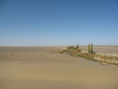 敦煌近郊集落「南湖」郊外の荒漠中の河川「西土溝」上流から眺めた、北方と砂漠の彼方の南湖集落
