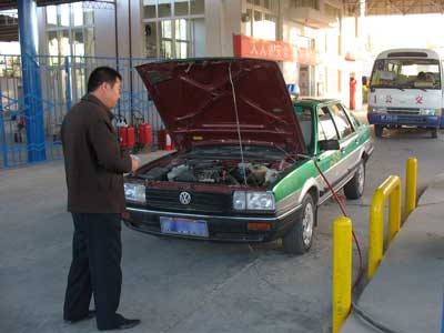 中国西部敦煌から安西（瓜州）方面の漢代遺構の見学出発前に市内燃料スタンドにて補給するチャーター・タクシーと司機のW氏