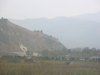丘上に頻繁に黄土造りの古城塞を見る、中国西部甘粛の黄土地帯をゆく列車車窓