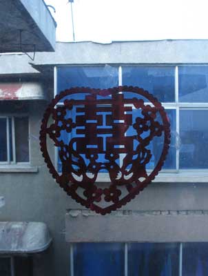 中国河南省三門峡の集合住宅の窓に貼られた新婚用（？）のハート形剪紙