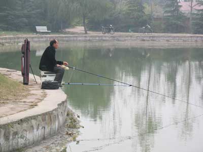 中国三門峡・宝輪寺塔近くの公園の池で見た竿受けを使う釣り人