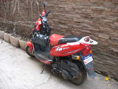 中国河南省三門峡の友人所有の、50cc以下の赤い二人乗りスクーター