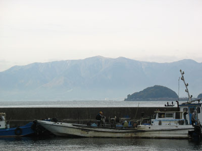 湖岸と沖島を結ぶ連絡船の発着港「堀切港」から見た、滋賀県の琵琶湖と沖島南部、対岸湖西地方に開る比良山脈