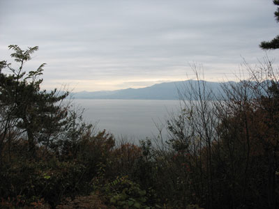 滋賀県琵琶湖沖島の山上から樹々越しに見た、湖西地方や比良連峰を望む北岸風景