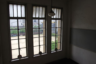 京都・元立誠小学校の階段室窓から見た、活用されず放置された運動場