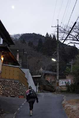 京都市東部の山から下山し、山と上空の月を振り返る参加者と夕刻の鹿ケ谷市街