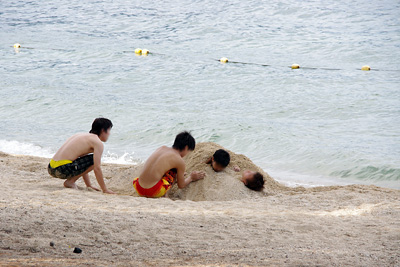 滋賀県琵琶湖西岸の近江舞子雄松浜の湖岸で、同行者らに砂に埋められる青年