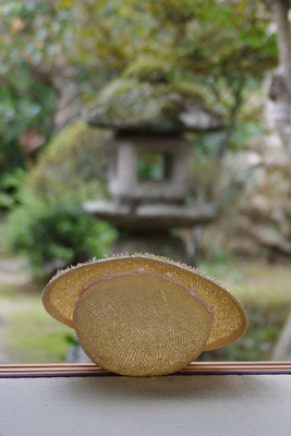 京都市北区上賀茂の旧家の離れの畳上に置かれた麦わら帽子越しに見た、庭や石灯籠