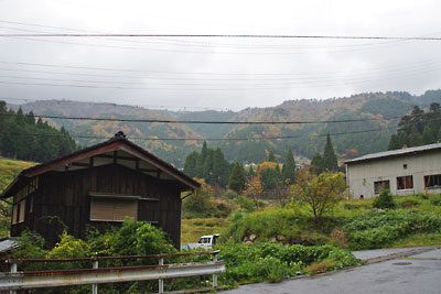 滋賀県北西・比良山塊西部支脈に抱かれた山間集落「畑」の家屋と紅葉が盛りの比良山塊主脈