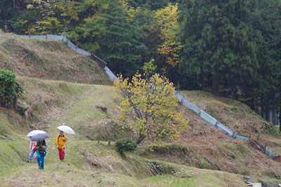 滋賀県北西・比良山塊西部支脈に抱かれた畑集落外れの、迷路のような棚田道を傘をさしつつ歩く山会参加者