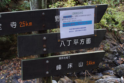 京都北山奥地の峰定寺から東にある分岐の標識と、洪水被害の警告貼り