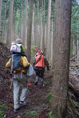 京都北山奥地の峰定寺東の分岐から支流谷の急登を進む山会参加者とハンター