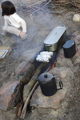 滋賀県湖南アルプス太神山中の野営地で作製した長炉型の竃と、夕食に備えた機材や、ホイル焼きされる焼き芋等々