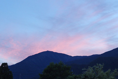 夕闇せまる滋賀県西部・比良山脈の打見山の影と、空を染める夕紅