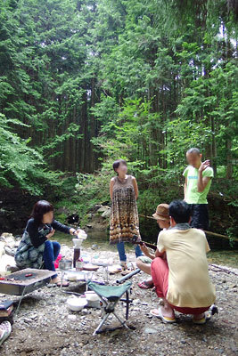 京都市北部山中の渓流際で行われた炭火会の食後、珈琲を入れたり、ギターを弾いたりして寛ぐ参加者たち