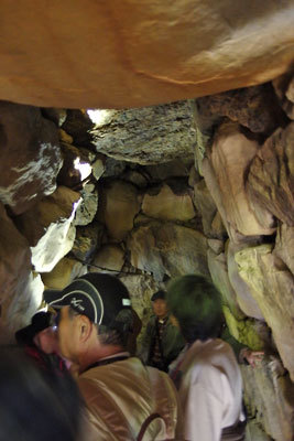 谷なかの森の最奥にあった史跡大江山古墳群「21号墳」の石室内部の石組みと見学者