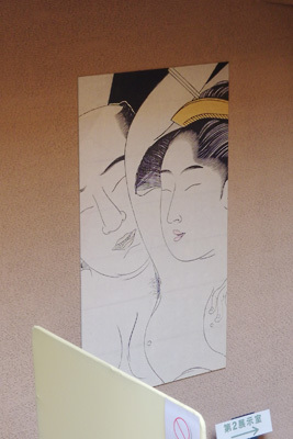 長閑で愛らしい感じが漂う、京都・細見美術館の通路壁面に貼られた春画展のポスター（鳥居清長「袖の巻」の一枚の部分を縦起し）