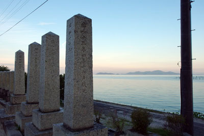 滋賀県「琵琶湖」特有の淡い夕色に染まる湖面に向かい立つ、西岸・南比良集落の戦没者墓碑
