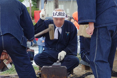 兵庫県・三木市の三木金物祭の催事広場で実演された、鋸刃を数枚重ねて金槌で伸す、古式鍛鉄の「鍛え」作業