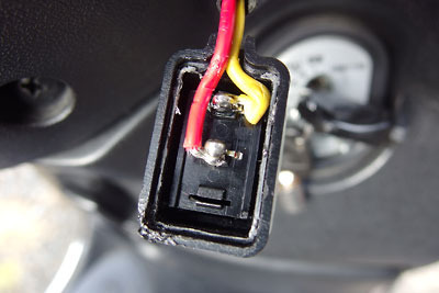 バイク用グリップヒーターの故障原因として疑われ交換したスイッチと、半田ごてで溶けた端部が適当に繕われたケース部分