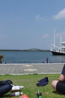 滋賀県南部・大津の浜大津港の芝生上で琵琶湖や観光船「ミシガン」をみつつ休息する平会参加者