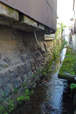 幻の大津城の堀との関連が指摘されている、滋賀県南部・大津旧市街の旧大津遊郭内を流れる小川と古い石垣