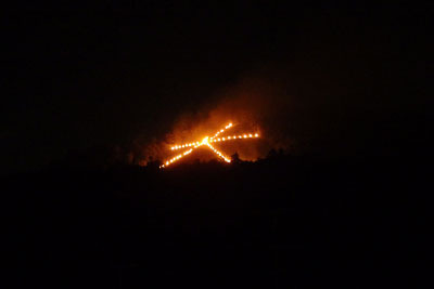 京都市街東部の神楽岡から見た、炎に勢いが出、火床周囲の多くの人影も確認できる、京都・五山送り火「大文字」