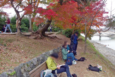 紅葉が盛りの京都府宇治の「塔の島」付近で休息する平会一行