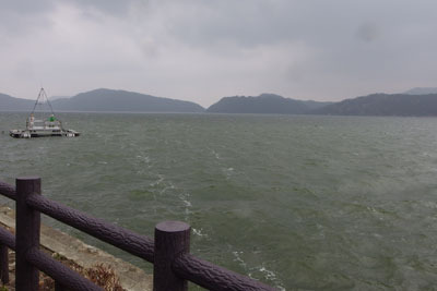風に波立つ、福井県三方五湖の水月湖と右奥の長尾島北東部（今回未踏部）、中央奥の浦見川の開削谷