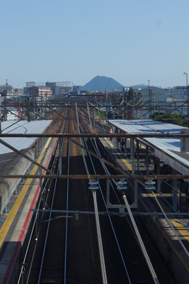 JR琵琶湖線瀬田駅の跨線橋上から見た、北上する鉄路と果てに聳える三上山（近江富士）
