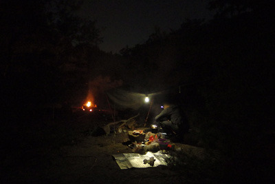 小さなキャンプファイヤーと炉端で過ごす野営地の夜
