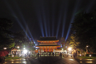 耿耿と照明に照らされた京都・平安神宮の応天門と境内のライブ会場から放たれるサーチライト光線群
