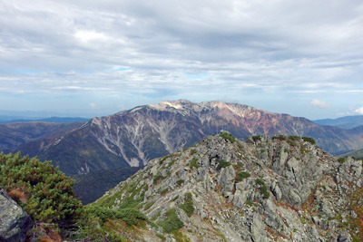 奥黒部・水晶岳山頂から見た、黒岳三角点頂越しの薬師岳