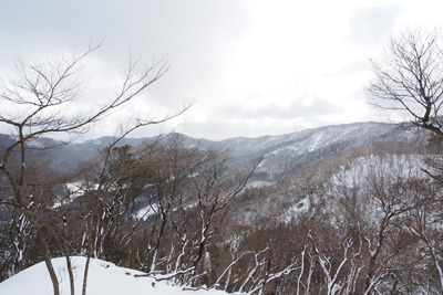 寺山峠北の林道上に開けた場所から見た花脊峠や天狗杉・寺山の山並みと麓の別所集落等。2022年1月15日撮影