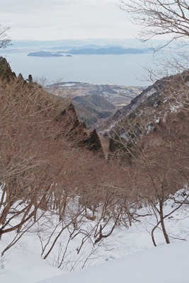 雪深い比良山脈の正面谷と麓の近江舞子や琵琶湖・沖島・湖東平野等。2022年2月12日撮影