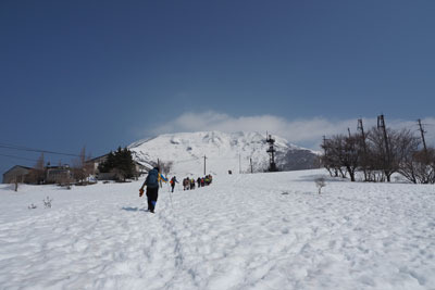 旧伊吹山スキー場のゲレンデ上に現れた雪を戴く伊吹山頂と、そこへと向かう大勢の登山者。2022年3月12日撮影