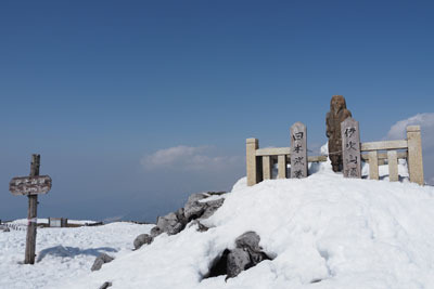 雪上にたつ伊吹山山頂の山頂標識と日本武尊像。2022年3月12日撮影