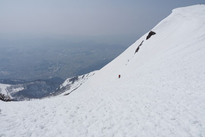 伊吹山上から旧スキー場へと落ち込む急斜の雪面とそこを下る登山者。2022年3月12日撮影