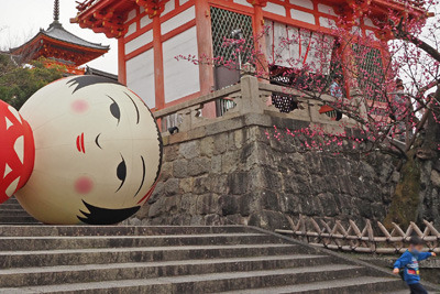 「ARTISTS’FAIR KYOTO 2022」で京都・清水寺仁王門横に設置された「Yotta」の巨大こけし作品「花子」から逃れる子供。2022年3月13日撮影