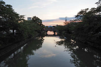 京都・聖護院付近の徳成橋から見た、嵐山方面の夕焼けとそれを映す琵琶湖疏水