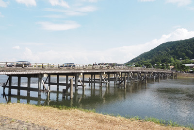 コロナ禍第7波最中の盆期間に嵐山渡月橋を渡るの観光車輌や人の賑わいと猛暑の夏空