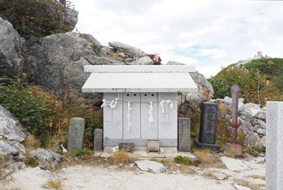 右上に甲斐駒ヶ岳山頂の祠が望める真新しい石造の駒ヶ岳神社本宮