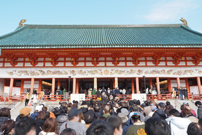 2023（令和5）年元日午前の快晴の空の下に聳える朱色鮮やかな京都・平安神宮本殿の大極殿前で参拝を待つ大勢の人々