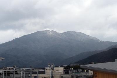 新幹線車窓よりみた、京都市街の果てに薄っすら雪を被って聳える比叡山