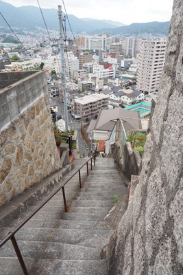 広島県呉市両城の、「両城の200階段」の途中から下を見た急段や呉市街に、階段住宅基壇の急な石積み